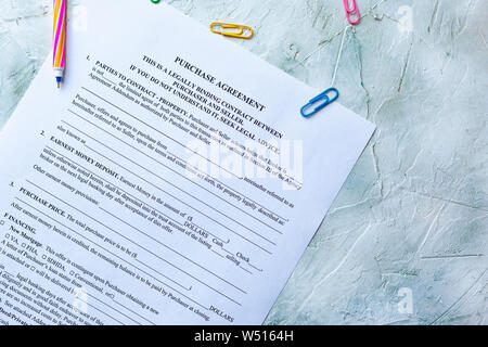 Filling blank Purchase agreement form. View from above Stock Photo