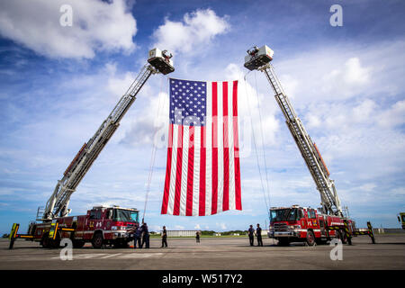 Personnel with Fire and Emergency Services, Marine Corps Installations Pacific - Marine Corps Base Camp Butler, hoist the American flag on Marine Corps Air Station Futenma, July 25, 2019. The personnel with Fire and Emergency Services were attending a practice for a change of command. U.S. Marine Corps Maj. Gen Paul Rock Jr. is scheduled to relinquish his post as Commanding General of Marine Corps Installations Pacific to U.S. Marine Corps Brig. Gen. William J. Bowers on July 26, 2019. (U.S. Marine Corps photo by Lance Cpl. Savannah Mesimer)