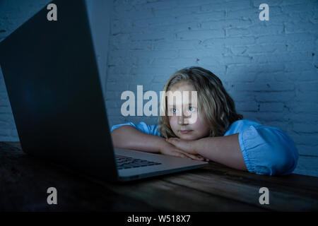 Scared sad girl bullied on line with laptop suffering cyber bullying harassment feeling desperate and intimidated. Child victim of bullying stalker so Stock Photo