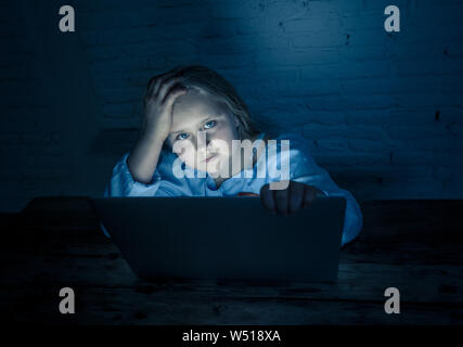 Scared sad girl bullied on line with laptop suffering cyber bullying harassment feeling desperate and intimidated. Child victim of bullying stalker so Stock Photo