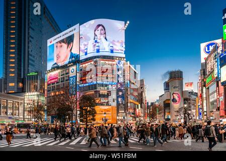 Shibuya Crossing, crowds at crossroads, colorful signs and illuminated advertising at dusk, railway station Shibuya, Shibuya, Udagawacho, Tokyo, Japan Stock Photo