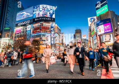 Shibuya Crossing, crowds of people at intersection, colorful signs and neon signs at the skyscrapers, dusk twilight, railway station Shibuya Stock Photo