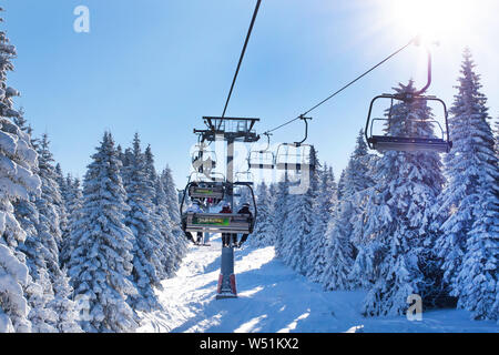 Kopaonik, Serbia - January 22, 2016: Ski resort Kopaonik, Serbia, people on the ski lift among the snowy white pine trees Stock Photo