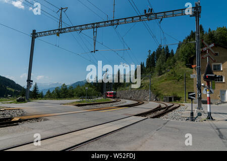 Langwies, GR / Switzerland - 24. July, 2019: the Rhaetian railway arrives at the small idyllic Langwies train station on the Chur - Arosa line Stock Photo