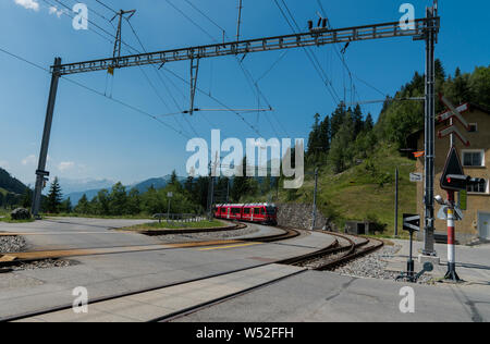 Langwies, GR / Switzerland - 24. July, 2019: the Rhaetian railway arrives at the small idyllic Langwies train station on the Chur - Arosa line Stock Photo