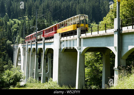 Langwies, GR / Switzerland - 24. July, 2019: the Rhaetian railway crosses the Langwies Viaduct over a deep ravine on the Chur - Arosa line Stock Photo