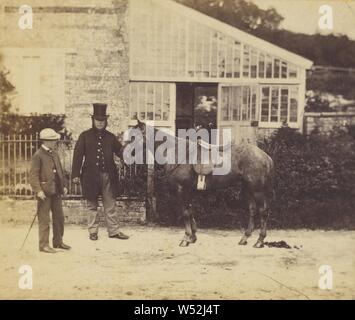 Man wearing top hat, holding horse, young boy in cap and walking stick next to man, Unknown, about 1870, Albumen silver print Stock Photo