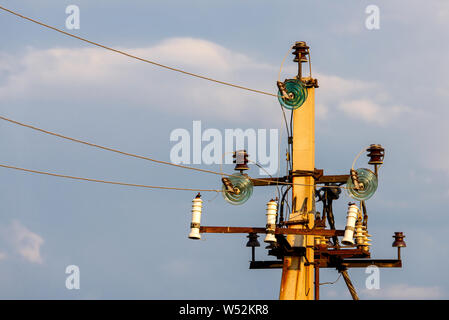 Close up of high voltage insulators with aluminium wire at power-tower. Stock Photo