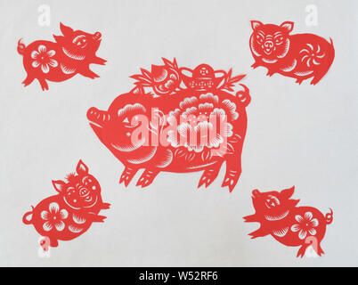 Chinese folk artist Li Yinjie shows paper-cutting artworks featuring pig to mark the upcoming Spring Festival or the Chinese New Year (Year of the Pig Stock Photo