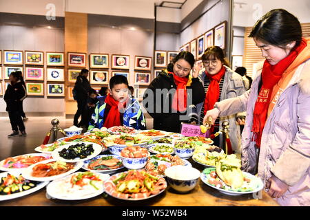 Visitors view the Spring Festival dishes made of polymer clay during an exhibition at Laishaoqi Gallery in Hefei city, east China's Anhui province, 25 Stock Photo