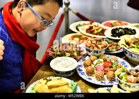 Visitors view the Spring Festival dishes made of polymer clay during an exhibition at Laishaoqi Gallery in Hefei city, east China's Anhui province, 25 Stock Photo