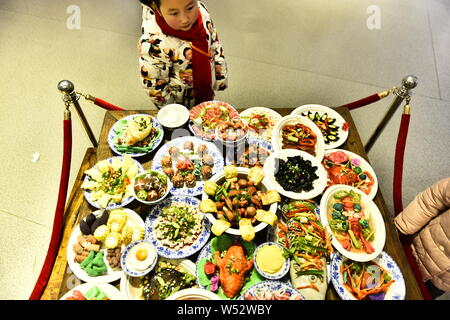 Visitors view the Spring Festival dishes made of polymer clay during an exhibition at Laishaoqi Gallery in Hefei city, east China's Anhui province, 25 Stock Photo