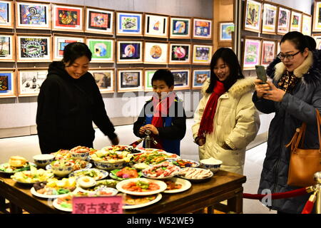 Visitors view the Spring Festival dishes made of polymer clay during an exhibition at Laishaoqi Gallery in Hefei city, east China's Anhui province, 25 Stock Photo