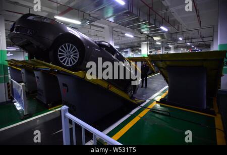 A local resident parks his car into an inclined position at a parking lot in Chongqing, China, 7 January 2019.   A parking lot was installed with incl Stock Photo