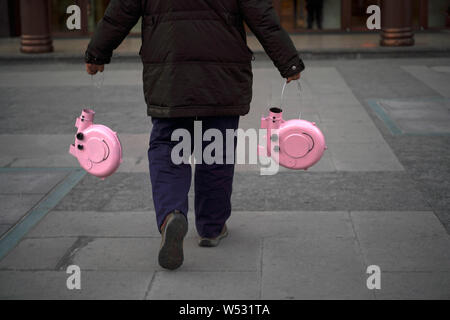 The father of Chinese Peppa Pig fan Han Bing carries two finished 'Iron Peppa' models outdoors in Beijing, China, 22 January 2019.   A Chinese fan of Stock Photo