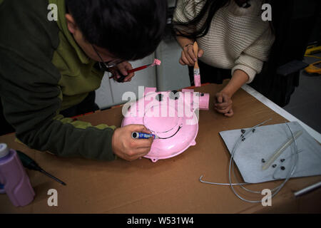 Chinese Peppa Pig fan Han Bing paints the mouth of a 'Iron Peppa' model at his workshop in Beijing, China, 22 January 2019.   A Chinese fan of the Bri Stock Photo