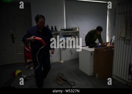 Chinese Peppa Pig fan Han Bing, right, and his father prepare tools to make 'Iron Peppa' models at their workshop of  in Beijing, China, 22 January 20 Stock Photo