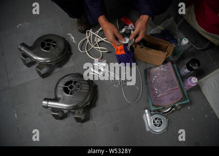 The father of Chinese Peppa Pig fan Han Bing prepares blower shells and other tools to make 'Iron Peppa' models at their workshop in Beijing, China, 2 Stock Photo