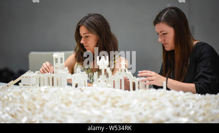 London, UK.  26 July 2019.  Visitors work with Lego at the preview of 'The cubic structural evolution project', 2004, by Olafur Eliasson at Tate Modern.  Exhibited for the first time in the UK, the artwork comprises one tonne of white Lego bricks inspiring visitors to create their own architectural vision for a future city and is on display until 18 August 2019.  The work coincides with the artist's new retrospective exhibition 'In real life' at Tate Modern on display to 5 January 2020.  Credit: Stephen Chung / Alamy Live News Stock Photo