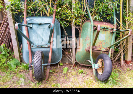 Two old wheelbarrows in a garden Stock Photo