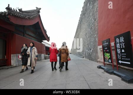 Tourists walk on the passage between the moat and the wall of the Forbidden City, also known as the Palace Museum, in Beijing, China, 2 January 2019. Stock Photo