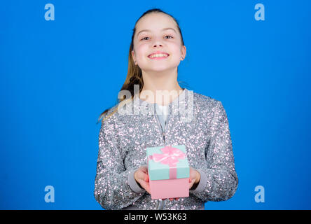 My precious. Special happens every day. Girl with gift box blue background. Black friday. Shopping day. Cute adorable child carry gift box. Surprise gift box. Birthday wish list. World of happiness. Stock Photo