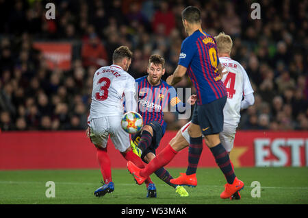 Lionel Messi of Barcelona, second right, challenges Sergi Gomez of Sevilla during the second match of the Spanish King's Cup quarterfinal at Camp Nou Stock Photo