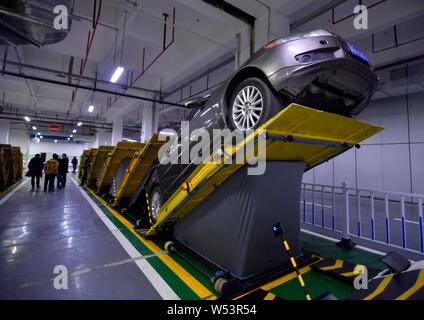 A local resident parks his car into an inclined position at a parking lot in Chongqing, China, 7 January 2019.   A parking lot was installed with incl Stock Photo