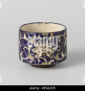 Tea bowl with floral scrolls, Stoneware tea bowl covered with a cream-colored glaze, blue enamel and painted in red, green and white. The lower part of the bowl is unglazed. The inside of the bowl is covered with a cream-colored glaze. The outside with lotus vines saved in a background of blue enamel. The lower part of the outer wall with a band with blue dots. Marked on the bottom with an unidentified, depressed three-character mark. Two chips in the edge. Kyo Gyuzan., anonymous, Japan, c. 1820 - c. 1850, Edo-period (1600-1868), stoneware, glaze, vitrification, h 7.2 cm d 8.9 cm d 4.7 cm Stock Photo