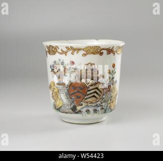 Cup with handle with the arms of the Van Isselmuden and Van Haersolte family, Porcelain ear cup painted on the glaze in blue, red, pink, green, yellow, black and gold. On the outer wall the arms of the Isselmuden and Van Haersolte families. The weapon to the right of the Isselmuden family has a twill with three common swifts on a red background. The weapon to the left of the Haersolte family has three squares on a golden background. The helmet sign consists of a crown with a man's head below and a basket above it. The weapons are surrounded by a multi-colored decoration with two columns, a Stock Photo
