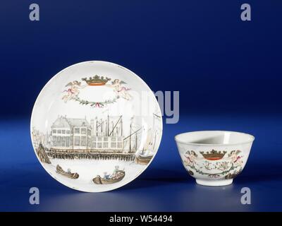 Bell-shaped cup and saucer with a port scene of Amsterdam, Bell-shaped porcelain cup and saucer, painted on the glaze in blue, red, pink, green, brown, black and gold. On the front of the dish a harbor view of the Nieuwe Stadsherberg in Amsterdam from the river IJ, on the river a few boats and ships manned by European men in eighteenth-century clothing. Above the cityscape a cartouche in the shape of two angels holding a crown and a garland. On the saucer the cartouche is empty, on the head it is filled with an unidentified monogram. The cup with the same decoration. Two cracks in the wall Stock Photo