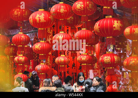 Local Chinese residents choose red lanterns, decals and other decorations for the Spring Festival or the Chinese New Year (Year of the Pig) on a stree Stock Photo