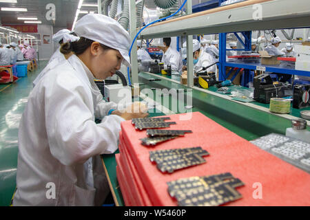 --FILE--Chinese workers manufacture electric fans on the assembly line ...