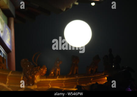 A supermoon is seen in the night sky over Yantai city, east China's Shandong province, 21 January 2019.   The year's first supermoon, when a full moon Stock Photo