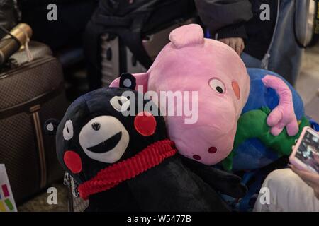 A Peppa Pig doll and a Kumamon doll are pictured at the waiting room of Beijing Railway Station in Beijing, China, 20 January 2019.   The 2019 Spring Stock Photo