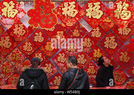 Local Chinese residents choose red lanterns, decals and other decorations for the Spring Festival or the Chinese New Year (Year of the Pig) on a stree Stock Photo