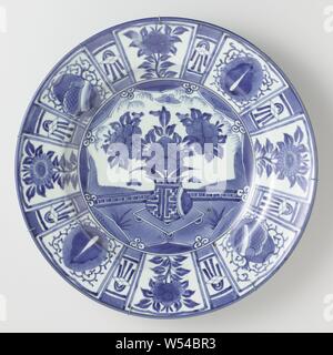 Dish with a 'cracking' decoration, Porcelain dish, painted in underglaze blue. On the shelf a flower vase in a star-shaped cartouche, around the cartouche four half, stylized lotuses. The wall is divided into compartments containing flower sprays and lucky symbols. Between the boxes a smaller box with a diamond and ribbons. The outer wall with a continuous flower tendril. Proen on the underside. Japanese imitation of the Chinese kraak porcelain. Arita, blue and white., anonymous, Japan, c. 1650 - c. 1674, Edo-period (1600-1868), porcelain (material), glaze, cobalt (mineral), vitrification, h 8 Stock Photo
