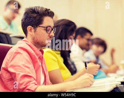 group of students with notebooks in lecture hall Stock Photo