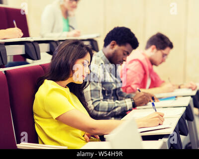group of students with notebooks in lecture hall Stock Photo