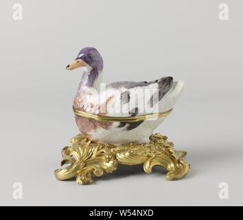 Box with lid in the shape of a duck on a base, Box of painted porcelain. The box has the shape of a duck. The duck sits on a gilt bronze rococo pedestal. The duck is partially painted in blue, brown, gray, violet and black, the head in violet and blue gray with a light red beak. The box is unnoticed., Meissener Porzellan Manufaktur, Meissen, c. 1740 - c. 1748 and/or c. 1750, porcelain (material), bronze (metal), gilding, h 5 cm w 16 cm × d 19.8 cm h 5.5 cm w 10 cm × d 15 cm h 9.5 cm w 9.5 cm × d 17.6 cm h 18.7 cm Stock Photo