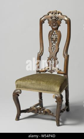 High back walnut chair with carving of C-volutes and sunflower. Angled S-shaped front legs, cross with scalloped side sports, Upholstered chair made of walnut. The hind legs give way backwards and the S-shaped forelegs placed on box hooves over the corner have a widening end and decorated swellings at the top. The cross has scalloped side sports, precursor with acanthus leaf between applied C-volutes. The high back has a central leaf with C-volutes and sunflower and a scalloped top with shell motif, both open. The threshold shows volutes with shell. Upper part of the styles is stretched S Stock Photo