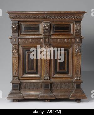 Miniature cabinet in oak with two drawers between the doors in the top and bottom cabinet, Miniature cabinet in oak, decorated with ebony. The high lower cabinet and the lower upper cabinet have two doors, two drawers are fitted between them. The skirting-board is strongly clipped on the corners and in the middle and the posts show a mirror, karyatide, ebony frame with diamond head and a cherub head from bottom to top. The sides of the lower cabinet show four framed panels and that of the upper cabinet an inlaid motif. Mirrors and edges on the doors, further grunting and carving., anonymous Stock Photo