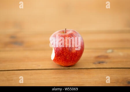ripe red bitten apple on wooden table Stock Photo