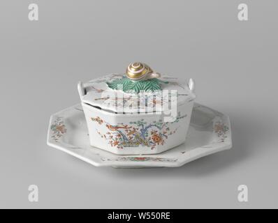 Butter dish lid topped by a knob shaped like a snail, Butter dish lid made of multi-colored faience, with kakiemon decor. All parts are painted in the muffle colors blue, red, green, black and gold with two bound hedges, flowering trees, a bird on a branch and loose birds. The lid has a snail like button. The lid is marked., anonymous, Delft, c. 1740 - c. 1760, earthenware, tin glaze, h 3.5 cm × d 10.7 cm Stock Photo