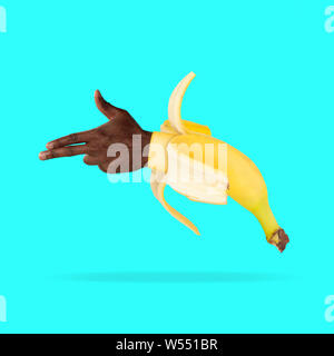 Making a shot. Banana with male hand showing the sign of a gun on blue background. Negative space to insert your text. Modern design. Contemporary art. Creative conceptual and colorful collage. Stock Photo