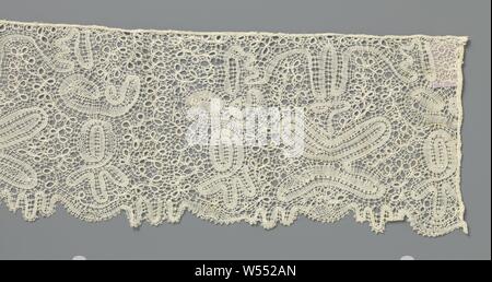 Strip bobbin lace with symmetrical composition with butterfly-shaped motif in center and surrounded by occhiolini loops, Strip of natural-colored bobbin lace, Eastern European lace. The repeating pattern consists of a more or less symmetrical composition in which the contours of the motifs are made with winding ribbons, which vary minimally in width. The composition consists in the center of a butterfly-shaped motif with a kind of canopy above it on which the same curling motifs hang down on both sides. The motifs are connected to each other by a loop pattern like with occhiolini. The ribbons Stock Photo