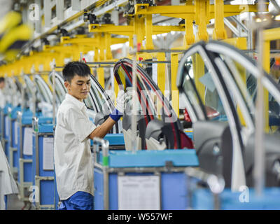 --FILE--Chinese workers assemble car engines at an auto plant of SAIC-GM, a joint venture between SAIC Motor and General Motors, in Wuhan city, centra Stock Photo