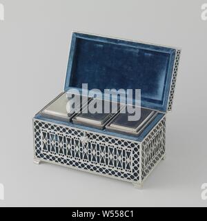 Tea box with two tea cans and a mixing canister. The inside wooden box is divided into three compartments by means of two wooden sliders. Both the interior and the sliders are covered with blue velvet. It is mounted in a silver holder with a hinged lid, containing the loose wooden lid of the box. The holder rests on four hollowly curved, fluted legs, closed at the top and bottom by profile edges. It has a smooth silver bottom but is cut open on all other sides. The four sides of the box holder each exhibit a field of angular guilloches against a background of railings with rosettes, surrounded Stock Photo