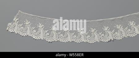 Strip of application lace with c-volute and spring-shaped blade, Strip of natural-colored Brussels application lace: bobbin lace appliqued on machine tulle. Spreading pattern with pulps on a fine hexagonal mesh. Repetitive motif with a rosette flower under which hangs a large feather-shaped leaf and a branch with small leaves. At the bottom of the leaf a horizontal c-volute with five lobes hanging. Motifs in linen with thicker contour threads. Ornamental stitches (needle stitches) in, among other things, the c-volute. The scalloped lower edge stems from the pattern with the leaf and the lobes Stock Photo