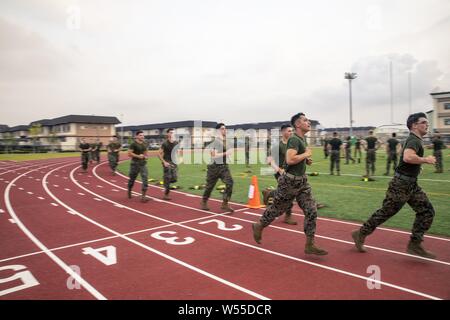 U.S. Marines with Headquarters and Headquarters Squadron conduct sprints during a squadron physical training event at Marine Corps Air Station Iwakuni, Japan, July 26, 2019, July 26, 2019. HandHS supports tenant commands at MCAS Iwakuni through air traffic control, aircraft rescue and firefighting and fuels along with many other capabilities. Regular unit physical training events like this help maintain readiness, morale and unit cohesion. (U.S. Marine Corps photo by Lance Cpl. Lauren Brune). () Stock Photo